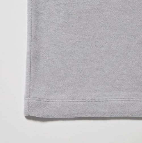 A close up of a grey t - shirt on a white surface.