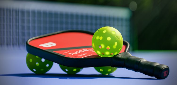 Pickleball paddle surrounded by pickleball balls 