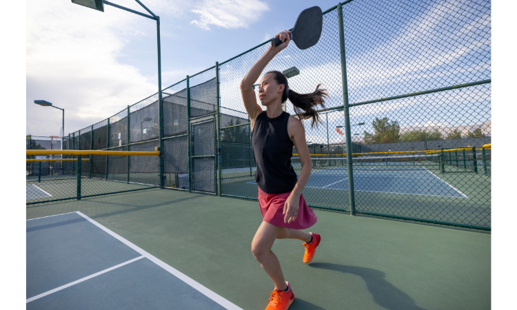 Athletic woman serving a pickleball in singles play