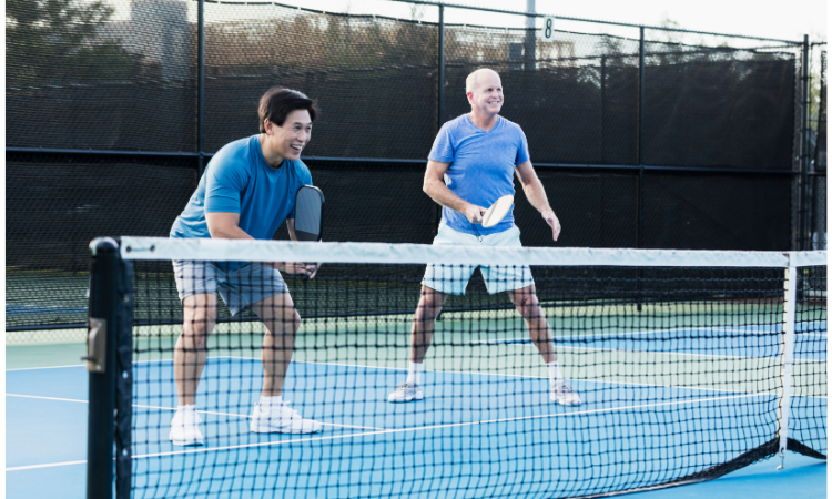 Two male pickleball players in athletic stance to hit a low ball in pickleball. 