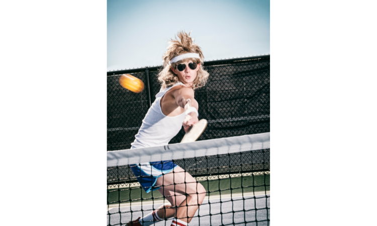 Male pickleball player in a retro outfit for a pickleball party.